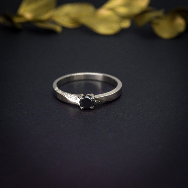 Anillo de compromiso con diamante negro natural de .25ct y 16 diamantes laterales elaborado en oro blanco de 14 kilates