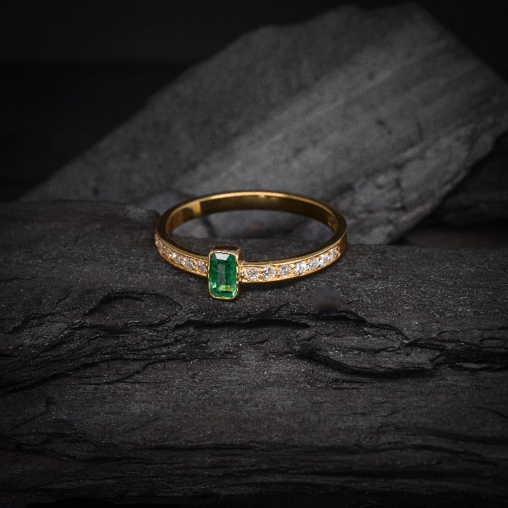 Anillo de compromiso con esmeralda natural y 14 diamantes laterales elaborado en oro amarillo de 14 kilates