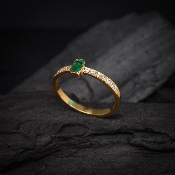 Anillo de compromiso con esmeralda natural y 14 diamantes laterales elaborado en oro amarillo de 14 kilates
