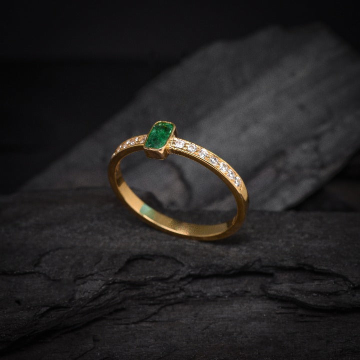 Anillo de compromiso con esmeralda natural y 14 diamantes laterales elaborado en oro amarillo de 14 kilates