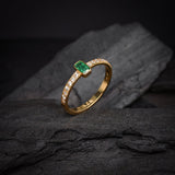 Anillo de compromiso con esmeralda natural y 14 diamantes laterales elaborado en oro amarillo de 14 kilates