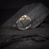 Anillo de compromiso con diamante natural de .15ct y esmeraldas laterales elaborado en oro amarillo y blanco de 14 kilates