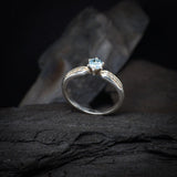 Anillo de compromiso con topacio natural y cristales laterales realizado en oro blanco de 14 kilates