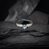 Anillo de compromiso con topacio natural y cristales laterales realizado en oro blanco de 14 kilates
