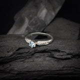 Anillo de compromiso con topacio natural y cristales laterales realizado en oro blanco de 14 kilates