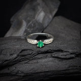 Anillo de compromiso con esmeralda natural y 10 diamantes laterales realizado en oro blanco de 14 kilates