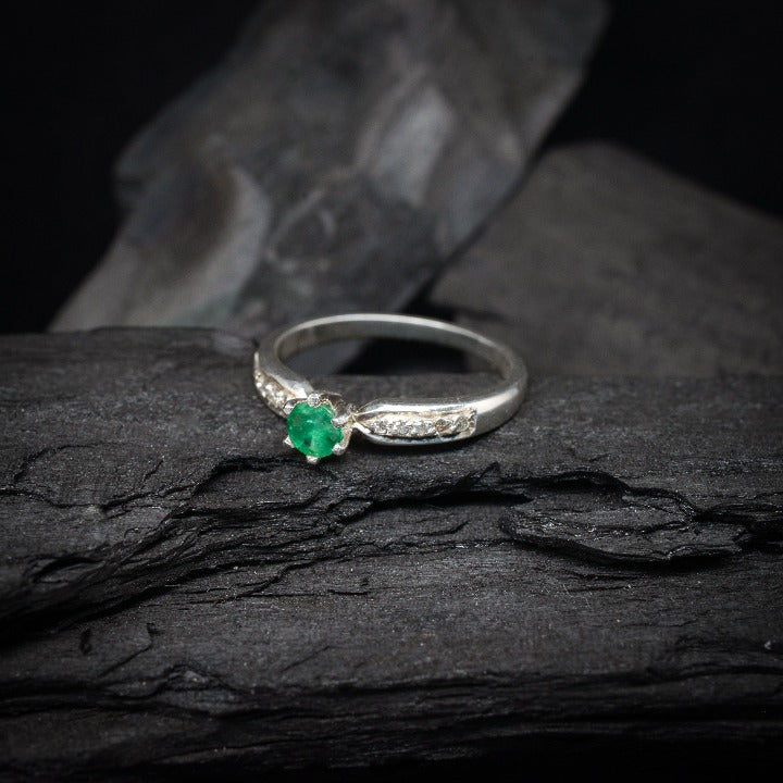 Anillo de compromiso con esmeralda natural y 10 diamantes laterales realizado en oro blanco de 14 kilates