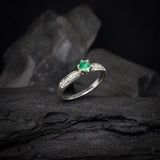 Anillo de compromiso con esmeralda natural y 10 diamantes laterales realizado en oro blanco de 14 kilates