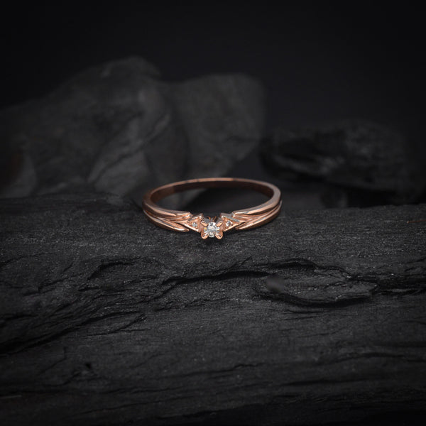 Anillo de compromiso con diamante natural central de .04ct y 2 diamantes naturales laterales elaborado en oro rosa de 14 kilates