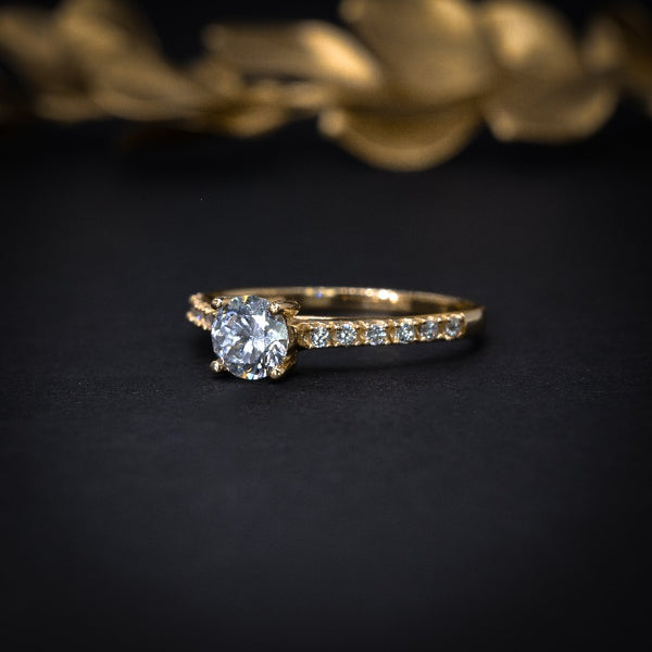 Anillo de compromiso con moissanita .50ct y cristales elaborado en oro amarillo de 14 kilates