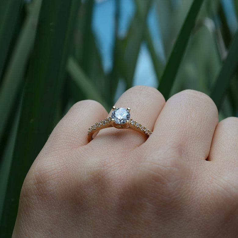 Anillo de compromiso con moissanita .50ct y cristales elaborado en oro amarillo de 14 kilates
