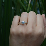 Anillo de compromiso con moissanita .50ct y cristales elaborado en oro amarillo de 14 kilates