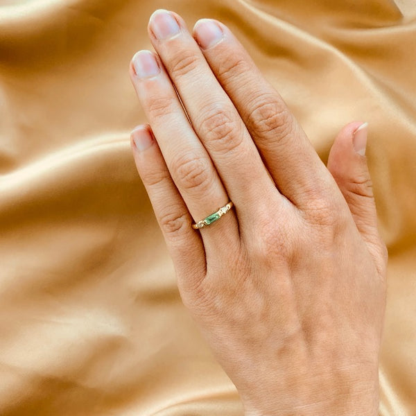 Anillo de compromiso con esmeralda natural de .15ct y 2 diamantes laterales elaborado en oro amarillo de 14 kilates
