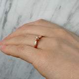 Anillo de compromiso con diamante natural de .04ct y 2 diamantes laterales elaborado en oro rosa de 14 kilates