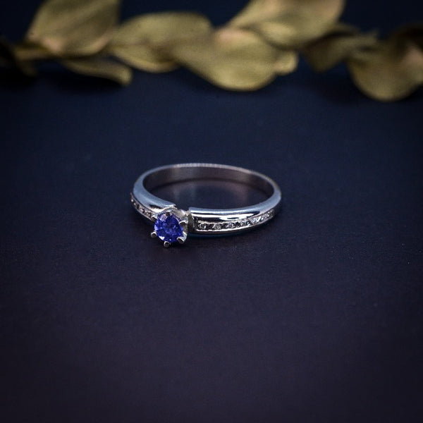 Anillo de compromiso con zafiro natural de .20ct y 10 diamantes laterales realizado en oro blanco de 14 kilates
