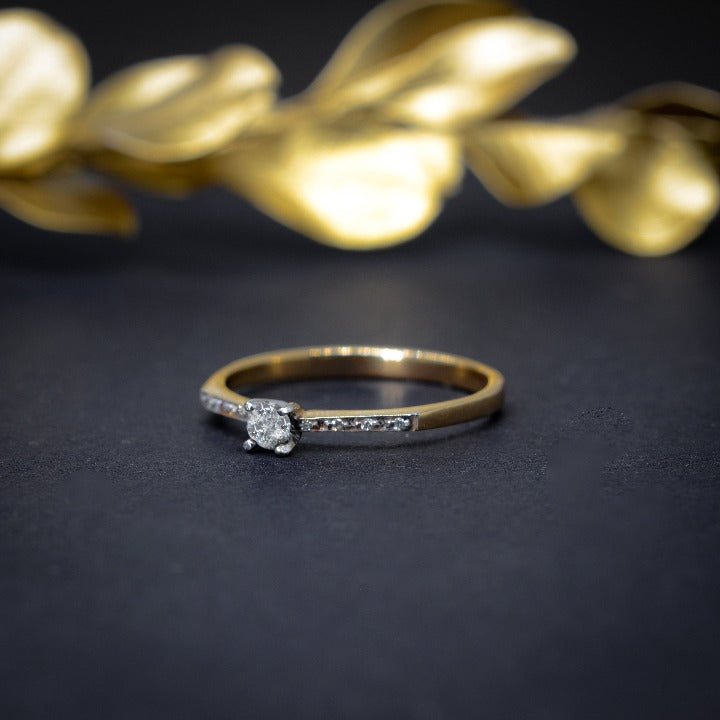 Anillo de compromiso con diamante natural de .10ct y 8 diamantes laterales en oro amarillo de 14 kilates