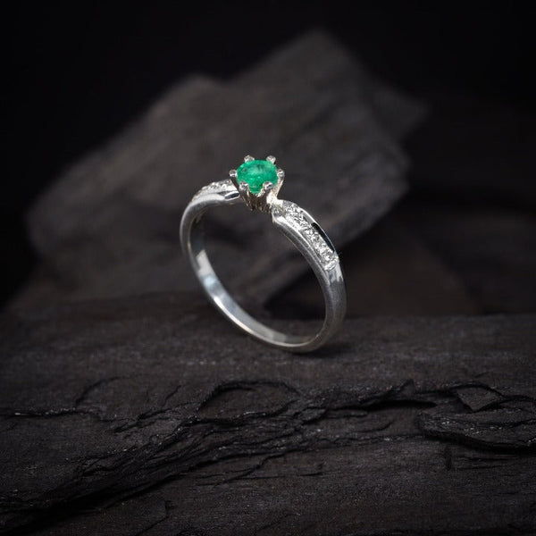 Anillo de compromiso con esmeralda natural y 10 diamantes laterales realizado en oro blanco de 14 kilates