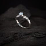 Anillo de compromiso con topacio natural y cristales laterales realizado en oro blanco de 14 kilates