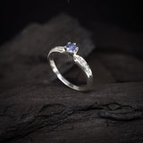 Anillo de compromiso con tanzanita natural y cristales laterales realizado en oro blanco de 14 kilates