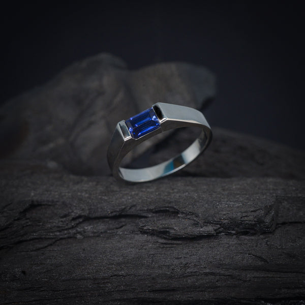 Anillo de compromiso con zafiro natural de .60ct corte esmeralda elaborado en oro blanco de 14k