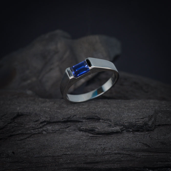 Anillo de compromiso con zafiro natural de .60ct corte esmeralda elaborado en oro blanco de 14k