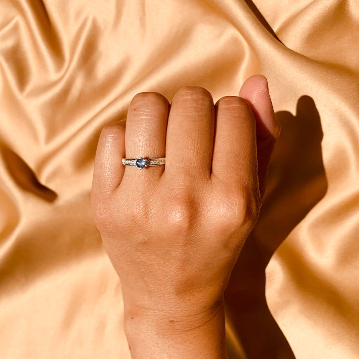 Anillo de compromiso con tanzanita natural y cristales laterales realizado en oro blanco de 14 kilates