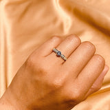Anillo de compromiso con tanzanita natural y cristales laterales realizado en oro blanco de 14 kilates