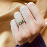 Anillo de compromiso con diamante natural de .15ct y esmeraldas laterales elaborado en oro amarillo y blanco de 14 kilates