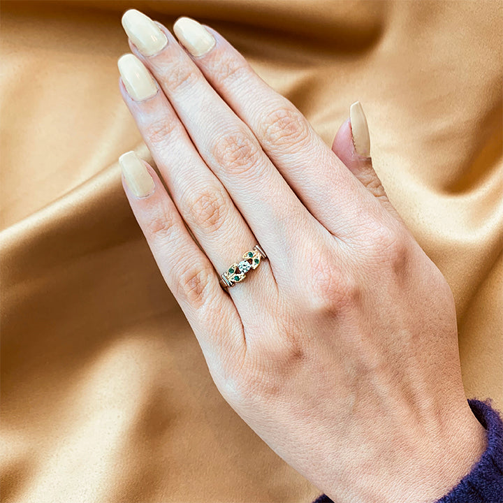 Anillo de compromiso con diamante natural de .15ct y esmeraldas laterales elaborado en oro amarillo y blanco de 14 kilates