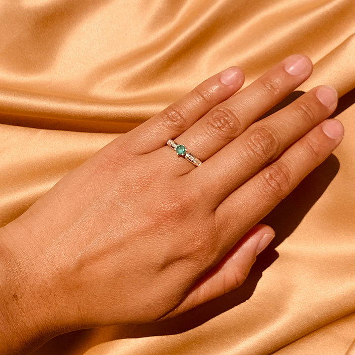 Anillo de compromiso con esmeralda natural y 10 diamantes laterales realizado en oro blanco de 14 kilates