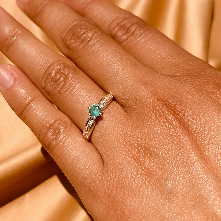 Anillo de compromiso con esmeralda natural y 10 diamantes laterales realizado en oro blanco de 14 kilates