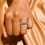 Anillo de compromiso con esmeralda natural y 10 diamantes laterales realizado en oro blanco de 14 kilates