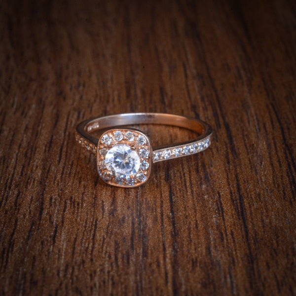 Anillo de compromiso con diamante natural de .25ct y 26 diamantes laterales realizado en oro rosa de 14 kilates