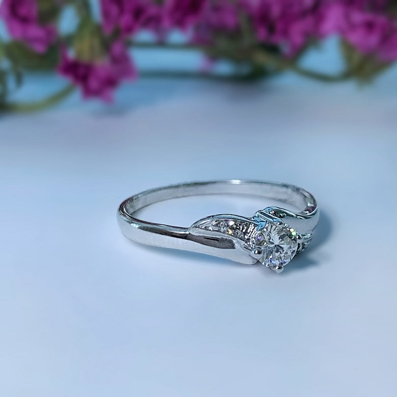 Anillo de compromiso con diamante natural de .20ct y 2 diamantes laterales elaborado en oro blanco de 14 kilates