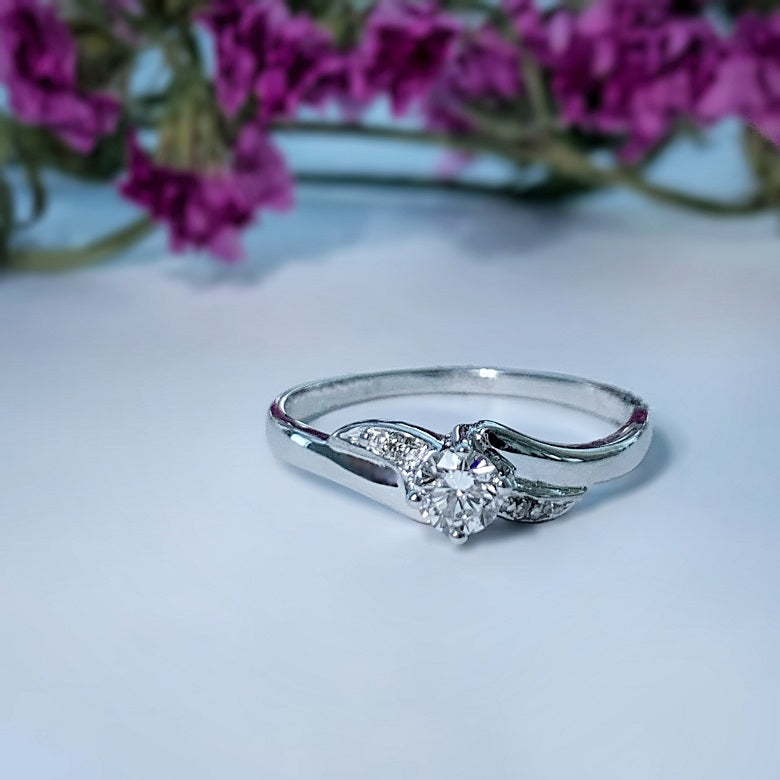 Anillo de compromiso con diamante natural de .20ct y 2 diamantes laterales elaborado en oro blanco de 14 kilates