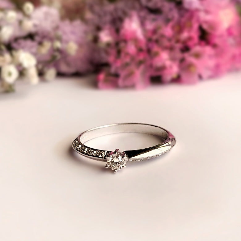 Anillo de compromiso con diamante natural de .06ct y 10 diamantes laterales elaborado en oro blanco de 14 kilates