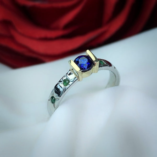 Anillo de compromiso con zafiro natural y esmeraldas elaborado en oro blanco de 14 kilates