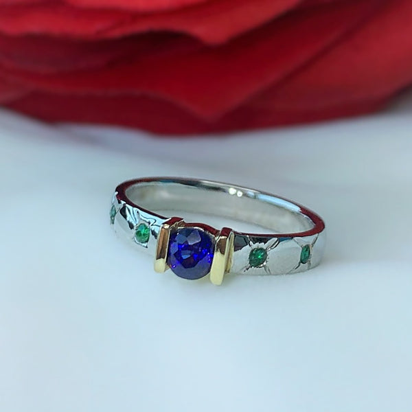 Anillo de compromiso con zafiro natural y esmeraldas elaborado en oro blanco de 14 kilates