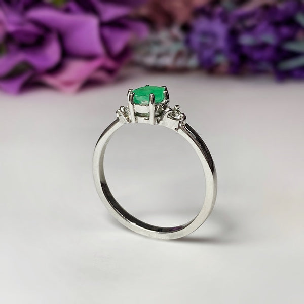 Anillo de compromiso con esmeralda natural de .50ct y 2 diamantes laterales elaborado en oro blanco de 14 kilates