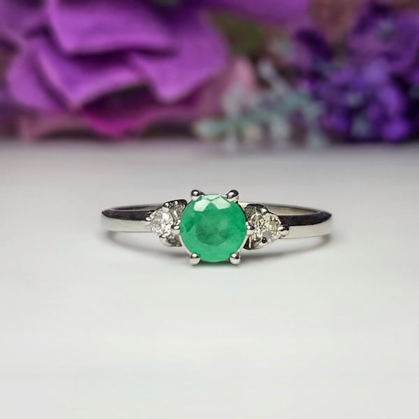 Anillo de compromiso con esmeralda natural de .50ct y 2 diamantes laterales elaborado en oro blanco de 14 kilates