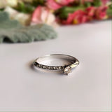 Anillo de compromiso con diamante natural de .06ct y 10 diamantes laterales elaborado en oro blanco de 14 kilates