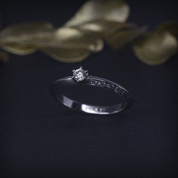 Anillo de compromiso con diamante natural de .06ct y 10 diamantes laterales elaborado en oro blanco de 14 kilates