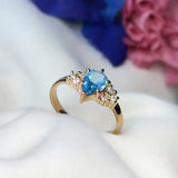 Anillo de compromiso con topacio corte gota y 6 diamantes laterales elaborado en oro amarillo de 14 kilates