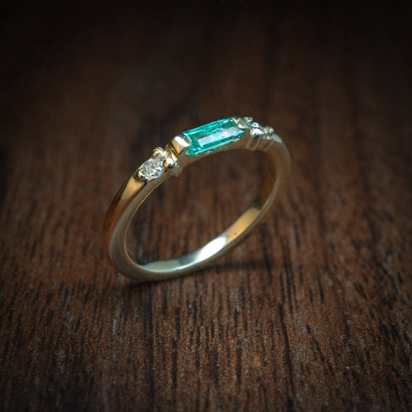 Anillo de compromiso con esmeralda natural de .15ct y 2 diamantes laterales elaborado en oro amarillo de 14 kilates